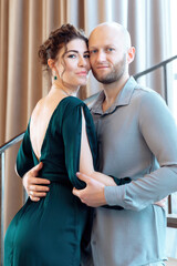 Portrait of beautiful young couple posing photo shooting indoors. Happy loving couple. Attractive curly woman and stylish bearded man. Vertical shot