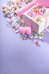 Cute high-colored Valentine day background, with pink colored champagne bottle, spring blossom flowers, little heart decor, on violet very peri color background flatlay copy space