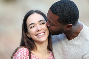 Fototapeta premium Man with black skin kissing on cheek a beauty woman