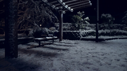 雪降る夜の公園とベンチ