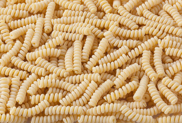 Uncooked fusilli corti bucati pasta background