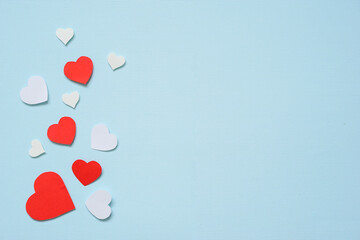Red and white paper cut into small hearts.  Paste on light blue paper, background concept for Valentine's .flat lay, copy space.