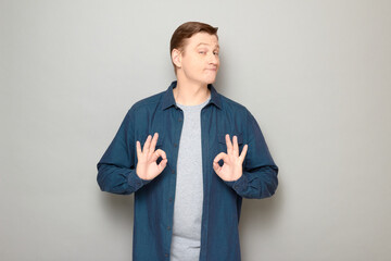 Portrait of happy mature man showing okay gestures and smiling