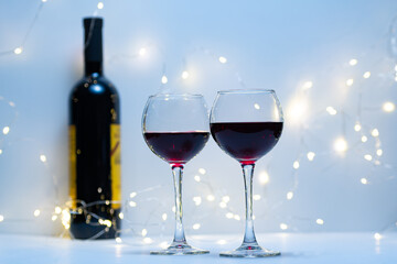Two glasses of red wine, in a romantic setting. Two glasses of red wine, a romantic evening for Valentine's Day. A postcard for holidays and dinners.