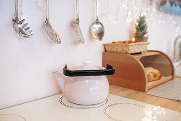 Steaming pink kettle with boiling water on stove. Retro teapot. Retro kitchen interior. Retro kitchenware. Selective focus