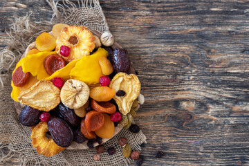 Healthy food: nuts and dried fruit on wooden background