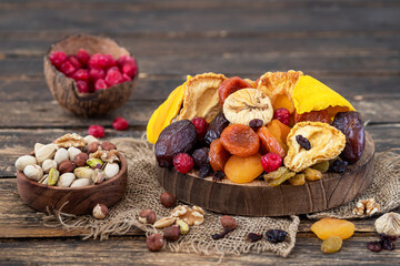Healthy food: nuts and dried fruit on wooden background
