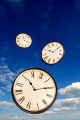 clocks flying over a blue sky, time concept