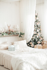 Beautiful christmas bedroom in light tone with christmas three and many gifts. Selective focus.