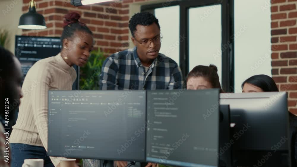 Poster developers brainstorming ideas looking at code on computer screens asking feedback from senior devel