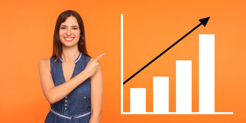 Portrait of happy joyful young woman standing, pointing aside and showing business growth graph....