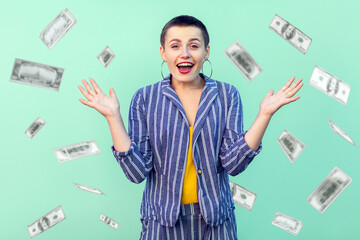 Oh my god, wow. Portrait of amazed young woman looking at camera with big eyes, absolutely shocked of money rain falling from up. indoor isolated on green background