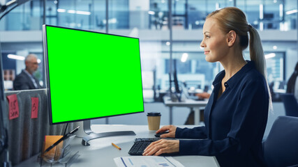 Diverse Modern Office: Confident Businesswoman Using Desktop Computer with Green Screen Mock Up Display. Manager Working on e-Commerce Support, Project Marketing, Data Analysis