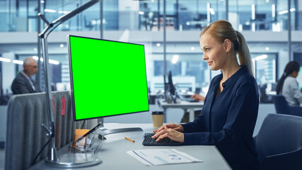 Diverse Modern Office: Confident Businesswoman Using Desktop Computer with Green Screen Mock Up Display. Manager Working on e-Commerce Support, Project Marketing, Data Analysis