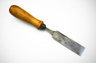 Forged chisel on wood on white isolate. An antique hand tool.