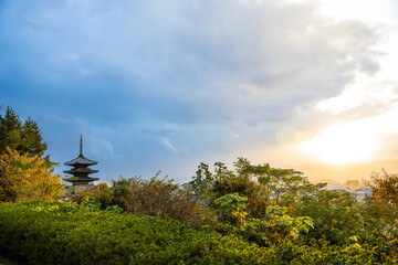 The top of the Yasaka-no-to Pagoda at the Hōkan-ji Temple with the sun piercing the storm clouds in Kyoto, Japan.