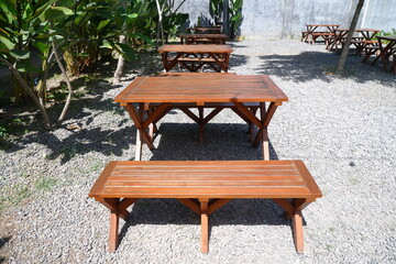 Table Decoration in the Open Garden and Long Chairs and Trees with Shady Plants in the Sun in a Restaurant