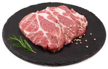raw pork meat with rosemar and peppercorn on black round stone plate isolated on white background. Clipping path and full depth of field