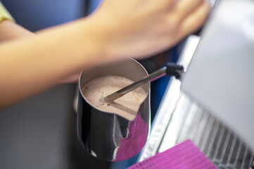 Barista making coffee and stirring milk