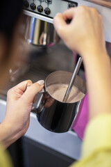 Fototapeta na wymiar Barista making coffee and stirring milk