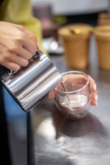 Close up picture of a womans hands pouring cocoa into the glass