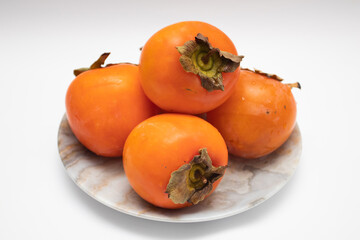 Fresh Ripe orange Persimmons on a plate