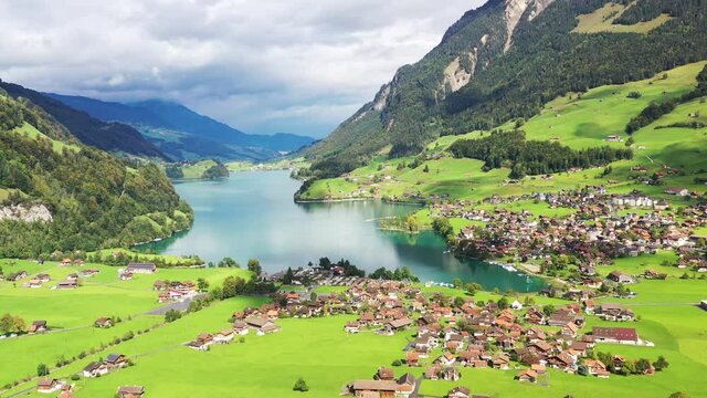 A village Lungern in Switzerland. Field  and houses. A sunny day and a mountain valley. Landscape from drone.