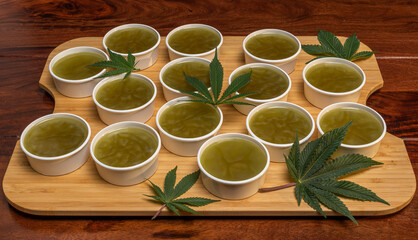 Making of marijuana green salve on wooden brown table