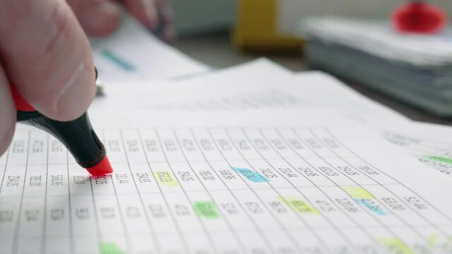 Close-up of a marker making notes on financial statements for audit.