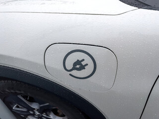 Modern car with electric charge port insignia logotype