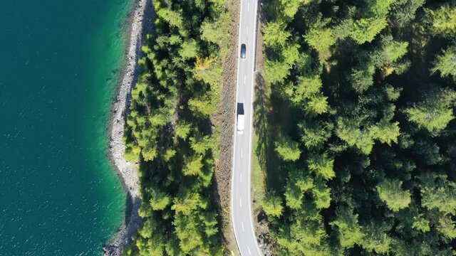 The road by the lake in Switzerland. Summer landscape from the air. Forest and road with curves.