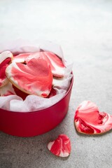 Decorated heart shaped cookies in red box on grey background. Gingerbread with sugar marble icing. Mother's day, Women's day, Valentine's day. Homemade present. Selective focus.