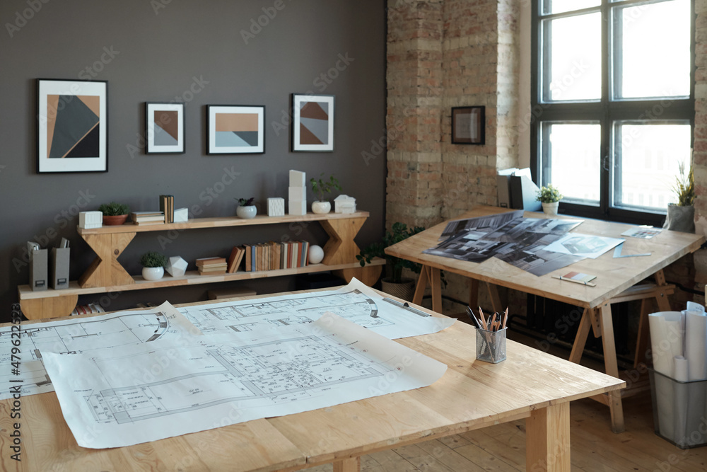 Poster Group of blueprints with architectural sketches on large wooden table in contemporary office or workshop