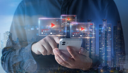 Live video marketing concept.Double exposure of business man using mobile phone and night cityscape