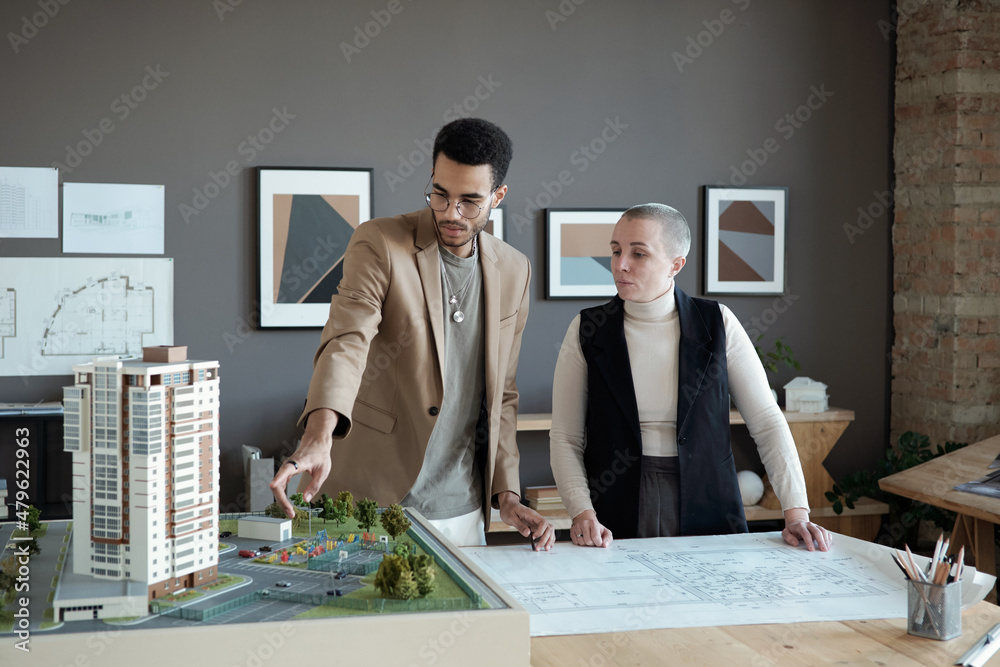 Poster Two professional engineers and architects discussing house layout while one of them making presentation of new project