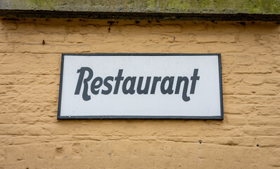 Restaurant sign on an old building with beige coloured facade