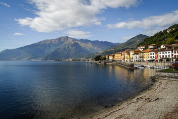 Lake como , bay of Domaso, Italy, typical houses of the village with mountains in background andy blue sky