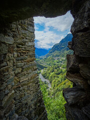 View through a medieval window of a castle on a valley in Switzerland,  San Bernardino road
