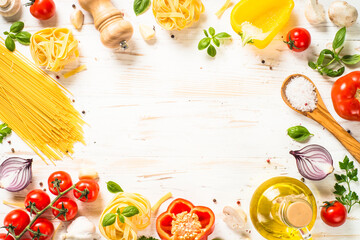 Fototapeta Italian food background on white kitchen table. Raw Pasta, olive oil, spices, tomatoes and basil. Food frame. Top view with copy space. obraz