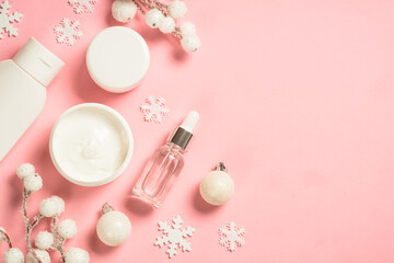 Winter cosmetic, skin care product. Cream, serum, tonic with winter decorations. Top view on pink background with copy space. - obrazy, fototapety, plakaty