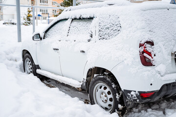 The car is buried under a layer of snow. Heavy snowfall in the city. The equipment stands under a...
