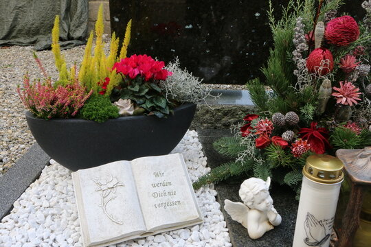 Elegante Grabgestaltung an einem christlichen Friedhof in Österreich zu Allerheiligen, Herbstbepflanzung und Trauerspruch "wir werden dich nie vergessen"