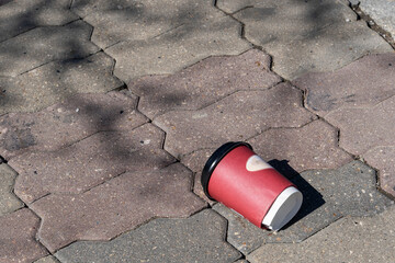 paper cup on the paving stones in the park