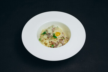 The amazing chef served a white bowl of spaghetti to visitors of the restaurant.