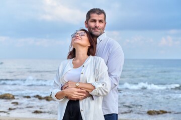 Outdoor portrait of mature couple hugging on the seashore