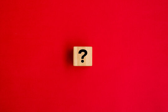 question mark on wood cube with red background