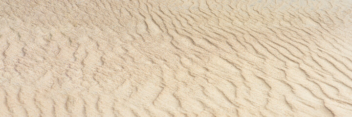 Plakat Desert sand dunes texture. Waves on the yellow sands of the desert. Close-up of a sandy beach.