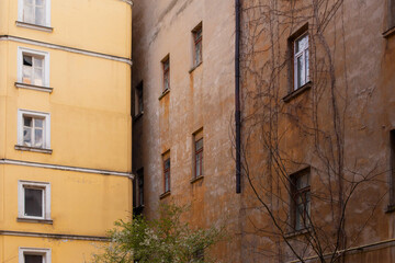 A corner of old building facade of typical houses in Odessacity center old town yards. Vintage windows, dirty scratched walls.