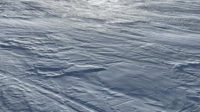 aerial view of a ski slope with a light blizzard moving powder snow upwards, vertical format, 4K