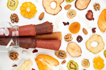 Close up of fruit lozenge different colors and almonds, orange, dried apricot, raisins, walnuts, dried apples and kiwi on white background. Concept of healthy assorted dried fruit for snacks.